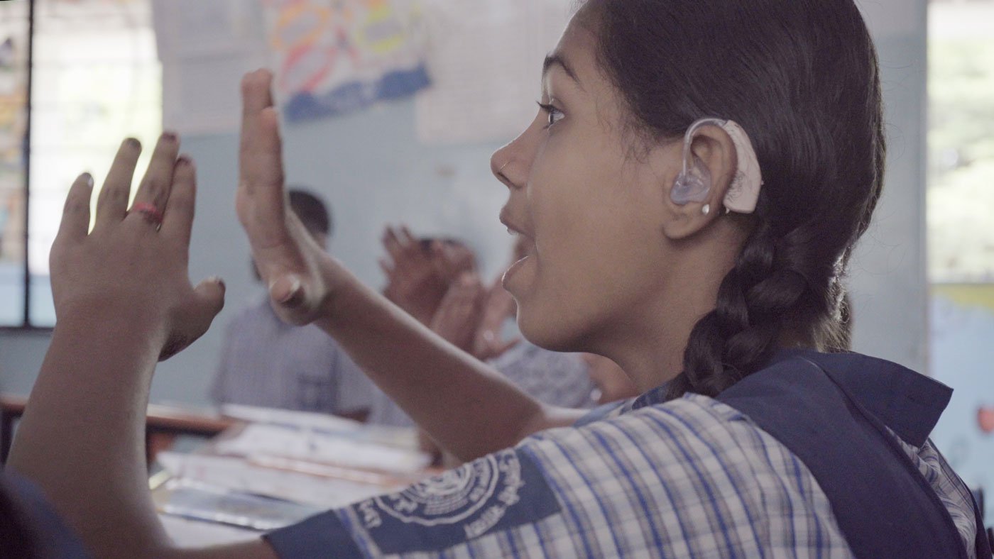 Girls learning signs from their teacher Mohan Kanekar respond to each sign and try and repeat the words in different notes and tones