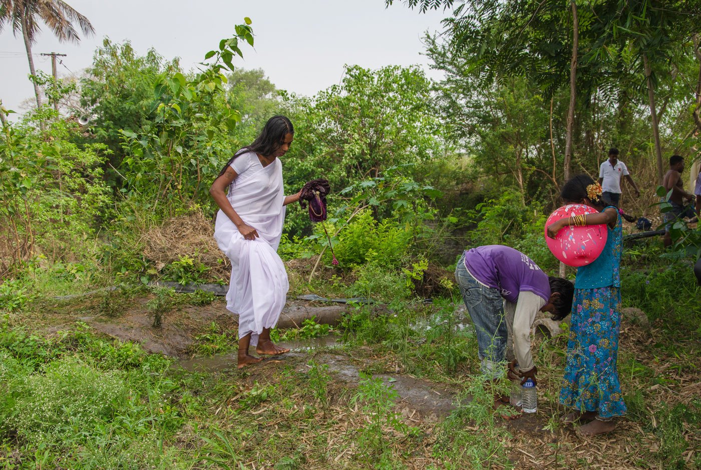 An aravani, dressed in white, walks away from the temple; she usually continues to mourn the death of Aravan for up to a month