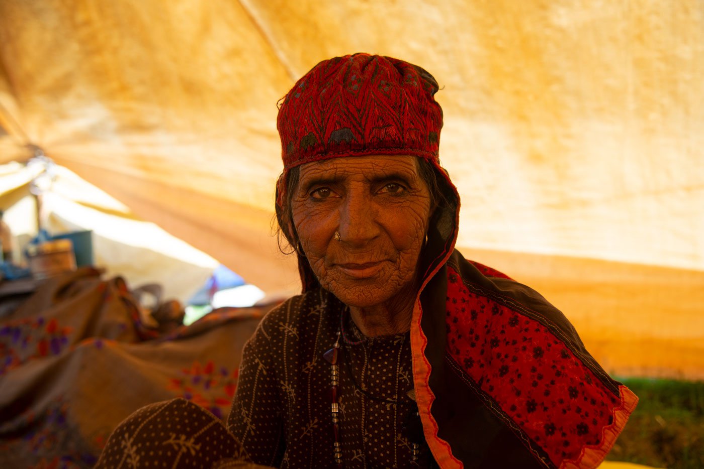 Zohra Bibi is wearing a traditional handmade embroidered cap. She says, 'We migrate every year as our men get some extra work'