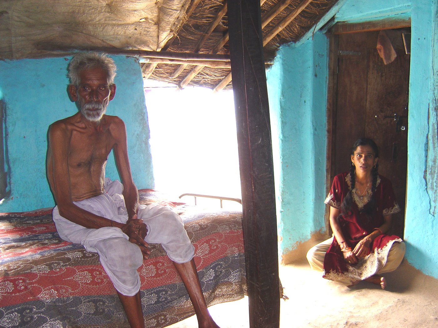 Shamrao Khatale sitting on bed with daughter in law in background