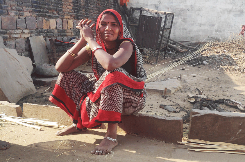 Rajabeti sitting near the broken roads