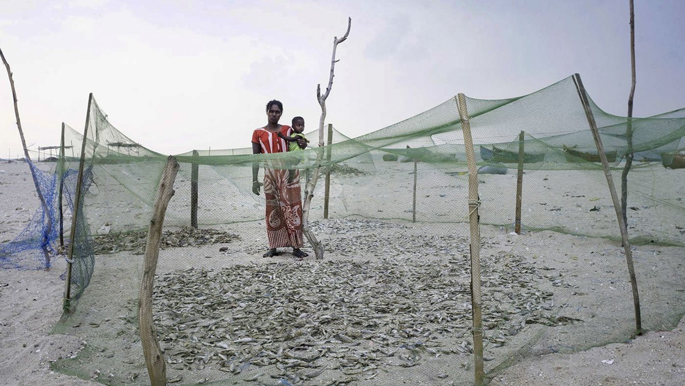 Woman and child standing by fish nets