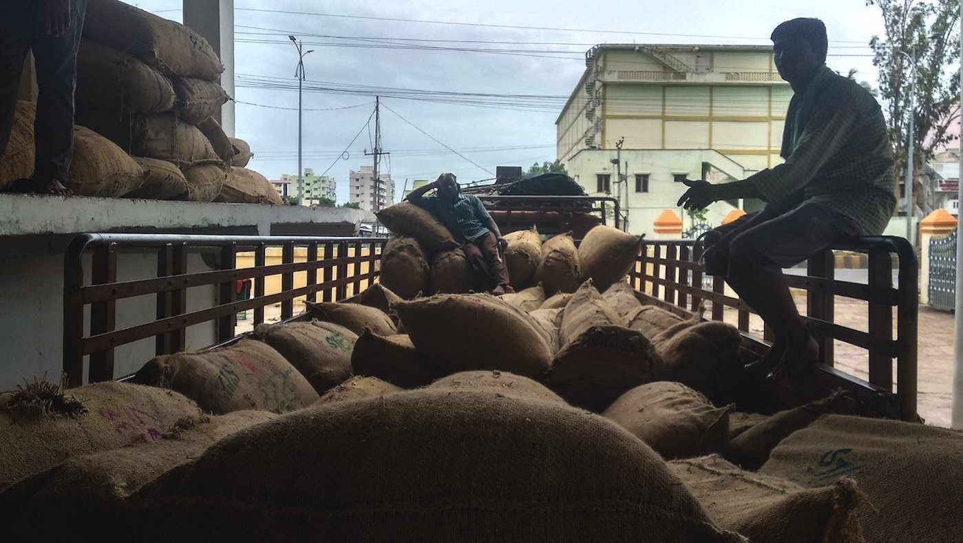 men sitting in truck with sacks of chilli