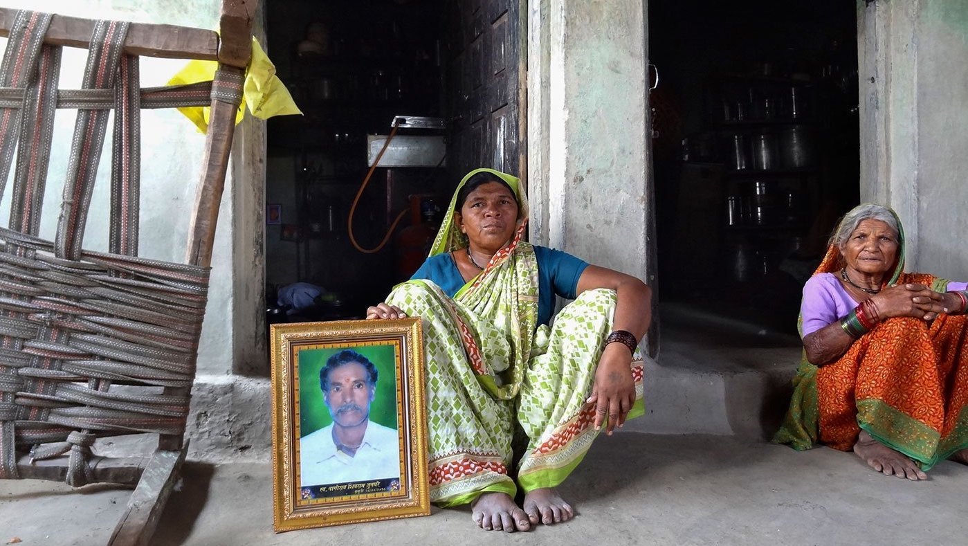 Women sitting with photo of deceased man