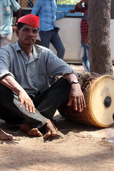 man sitting next to a drum