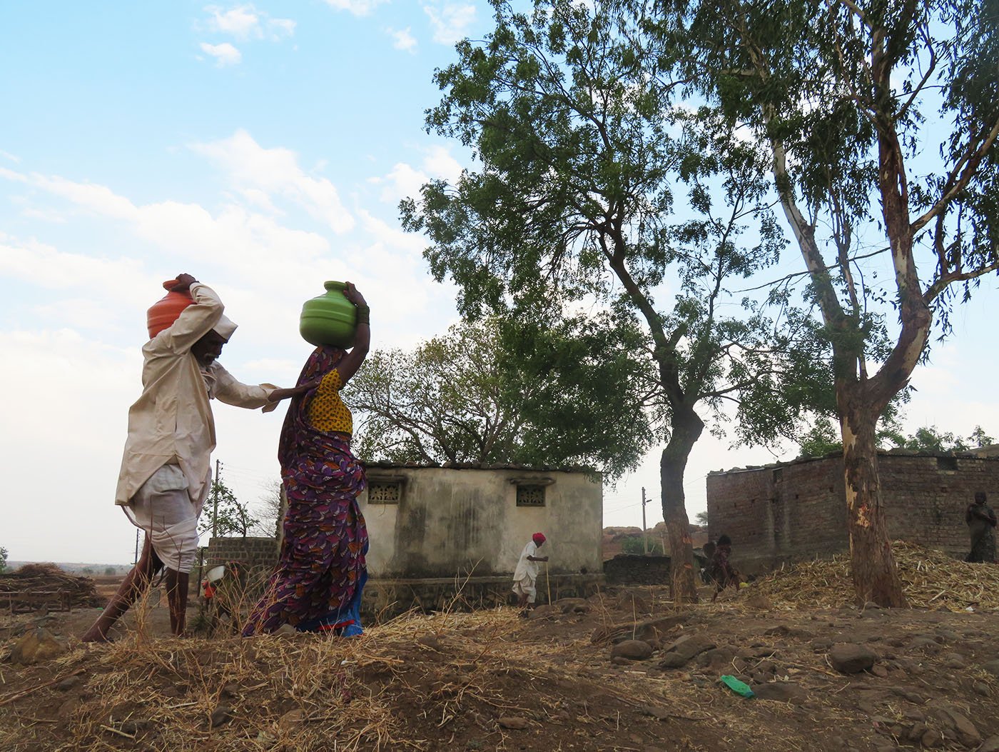 Ramu and Kewalbai carrying the pots home