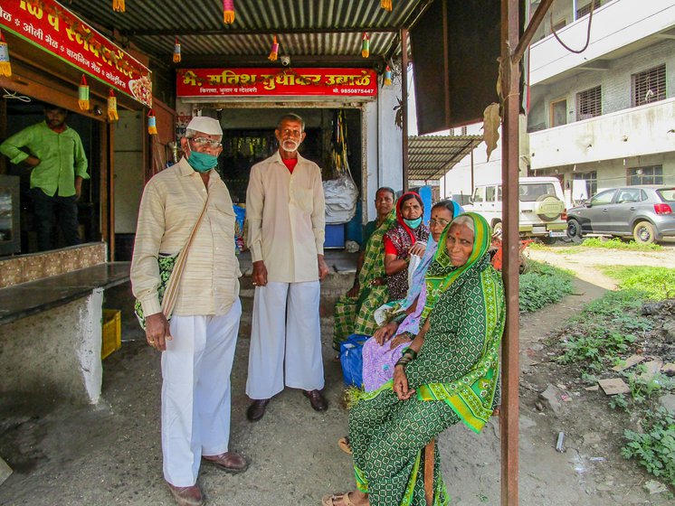 Shivaji Borkar (second from the left) and others wait for a shared auto to take them to their onward destination from Paud