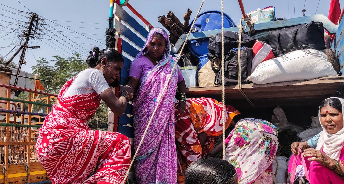Women boarding the truck, heading towards the march.
