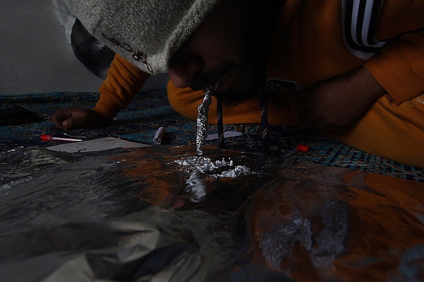 Right: In Budgam,  a young man ingesting heroin 
